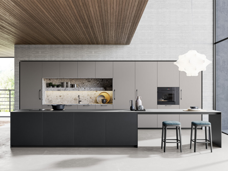 Tall and base units CX 10 ultramat mineral grey with handle. Worktop, back panels and sides in stoneware Gris Abujardado Iseo. Island base units CX 10 ultramat mineral grey with push pull opening. Island worktop and side panels in Fenix nero ingo.